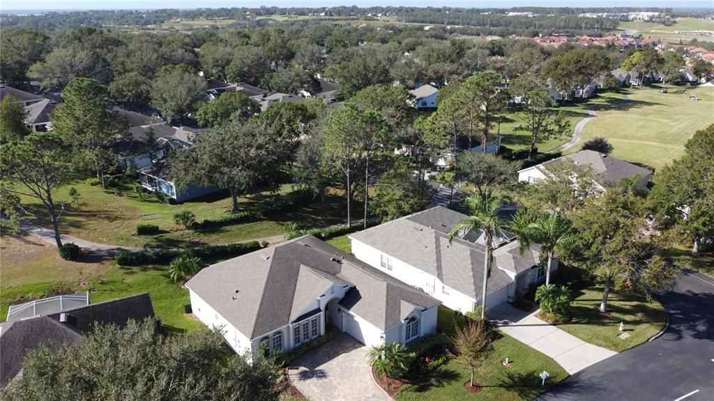 Over view of home and golf cart path behind shrubs