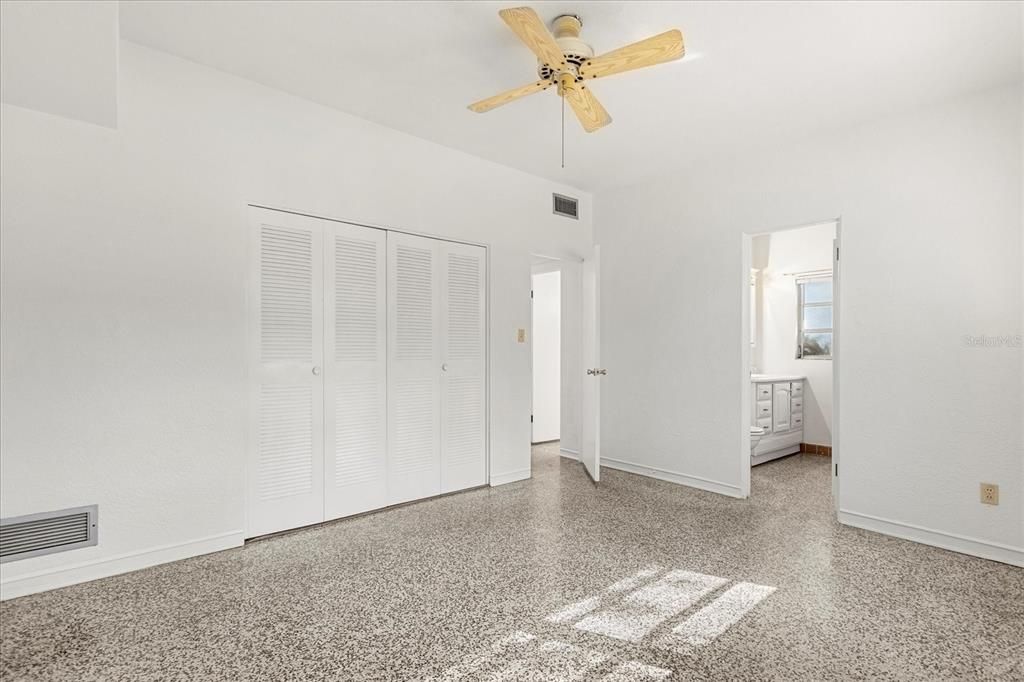 Primary bedroom: door to left goes to hallway, door right is en suite bathroom, behind photographer is dining room