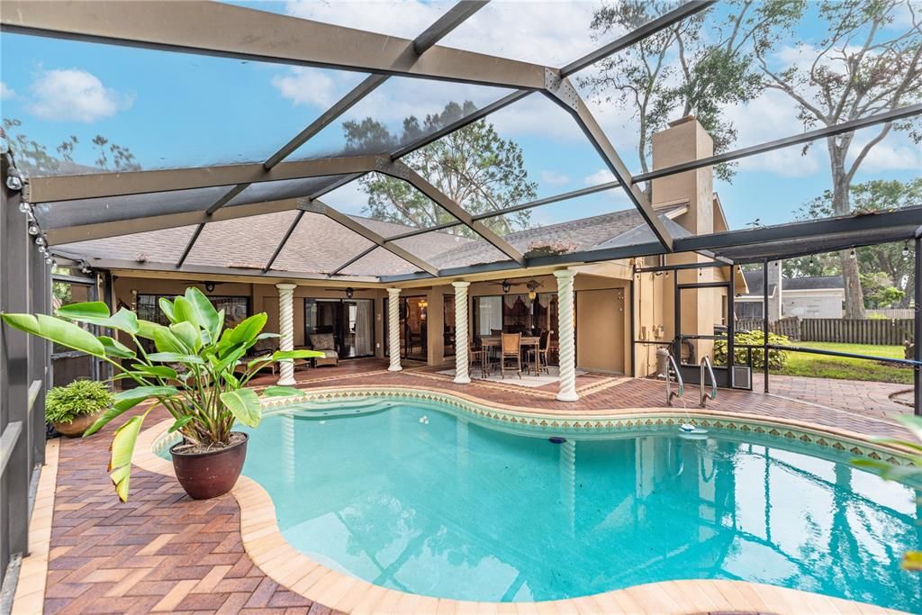 Screened lanai and pool area with ample covered spaces and a sprawling fenced yard, invite endless outdoor enjoyment and relaxation.