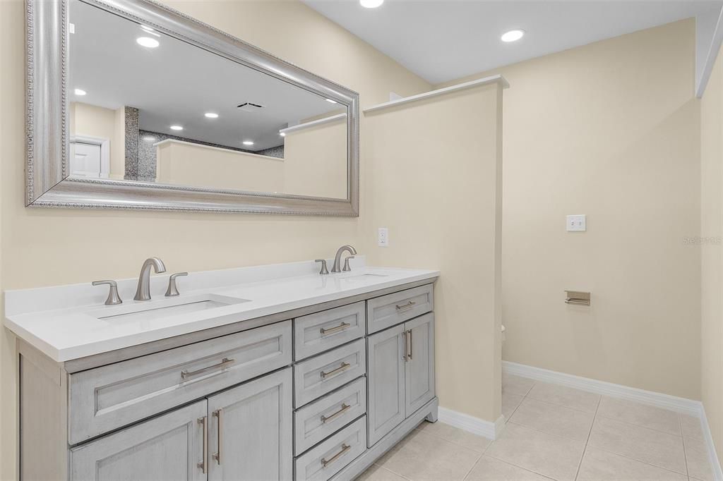 This bathroom off the primary BR features a new double vanity and on the other side of the wall is a private toilet area