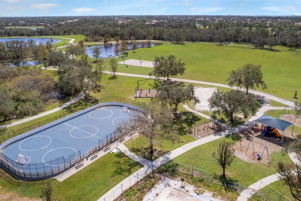 Aerial of Greenbrook Adventure park featuring the hockey rink, basketball courts, play ground, and sports fields.