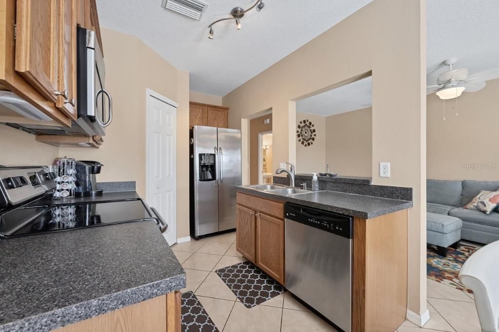 Galley style kitchen featuring wood cabinets, stainless steel appliances, and a large pantry.