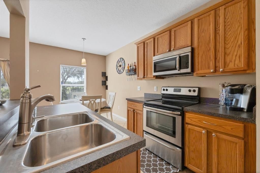 Galley style kitchen featuring wood cabinets, stainless steel appliances, and a large pantry.