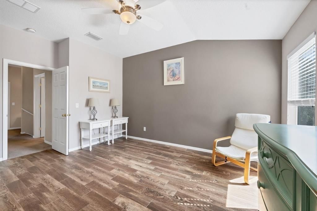 Owners suite featuring laminate flooring, a built out walk-in closet, and ensuite bathroom.