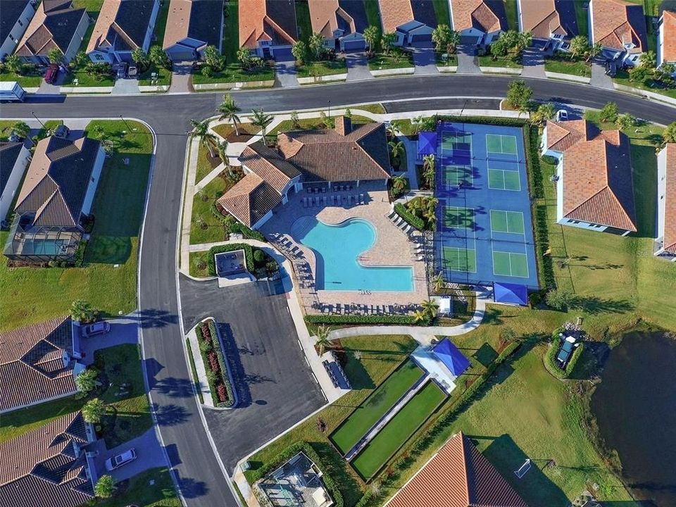 Aerial view of Venice Woodland's clubhouse with fitness center, heated pool and pickleball and bocce courts.  HOA fees cover these amenities, along with all of the yard work.