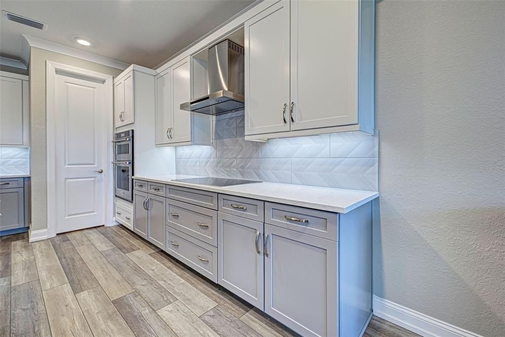 Beautiful kitchen features a Kitchen Aid induction cooktop with vent to outside.