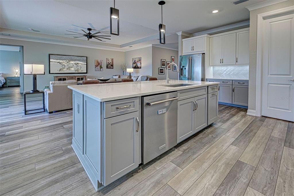 Keep the chef company at the roomy island with farmhouse sink and elegant pendant lights.