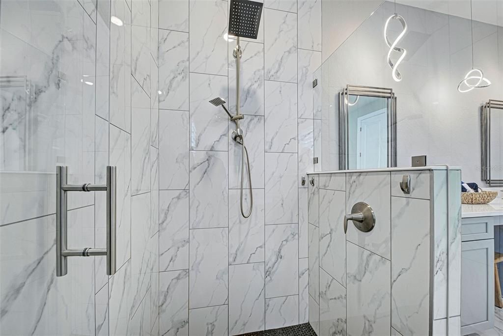 Brushed nickel rain head and hardware compliment this stunning, tiled walk-in shower.