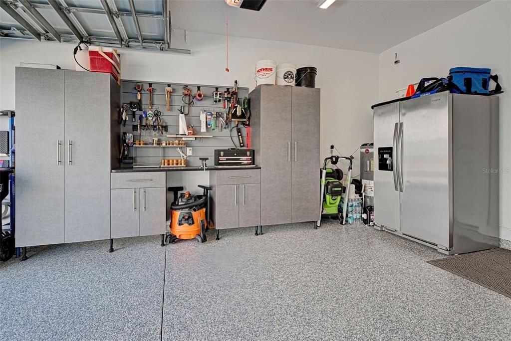 Garage has a custom workbench and shelving, along with attic insulation to keep it cooler.