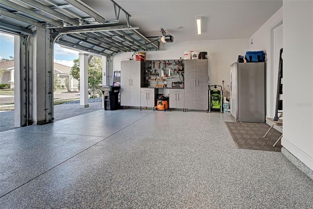 Customized garage with epoxy floors, hurricane rated garage door and 220V dedicated circuit for electric vehicle charging.