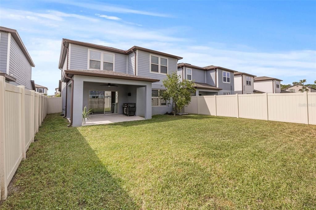 Large back yard with vinyl privacy fencing.