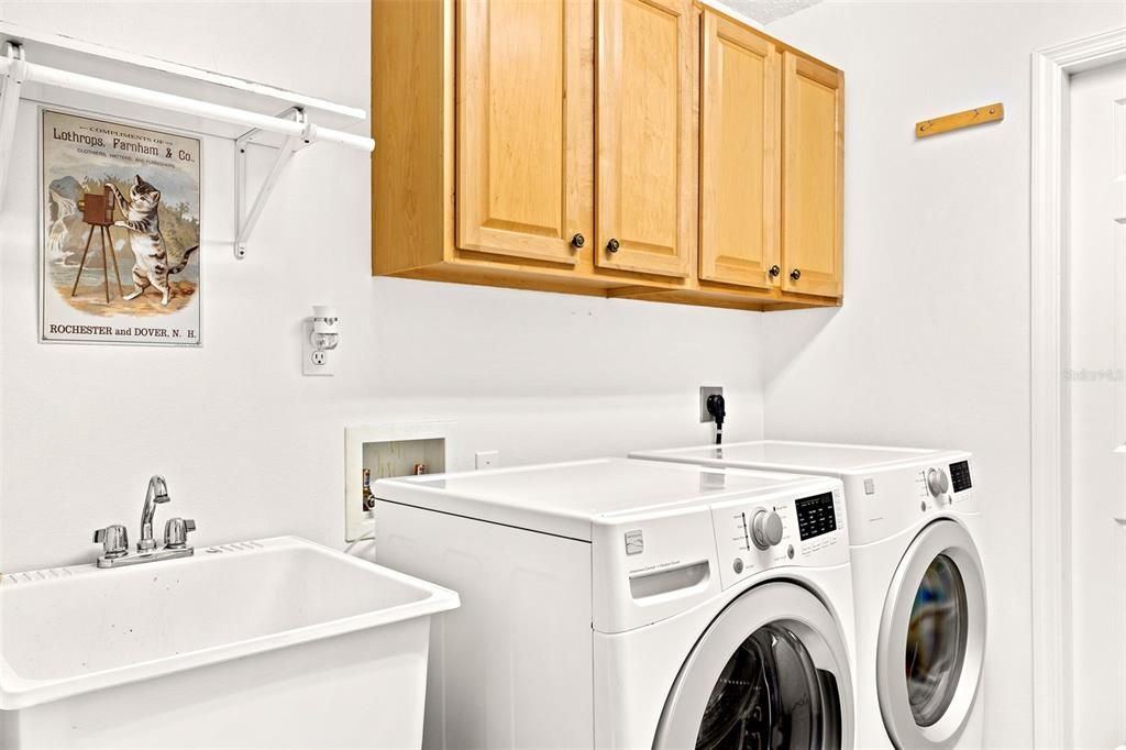 Interior laundry facilities include plenty of cabinets and a utility sink