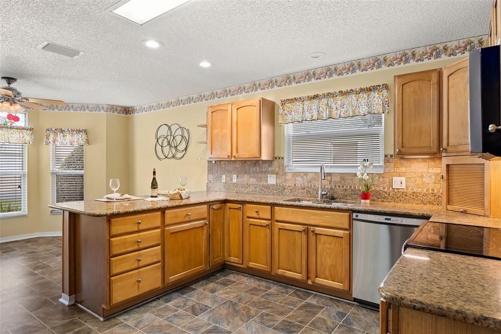 The eat-in kitchen boasts granite countertops, a double pantry with pull-out shelves