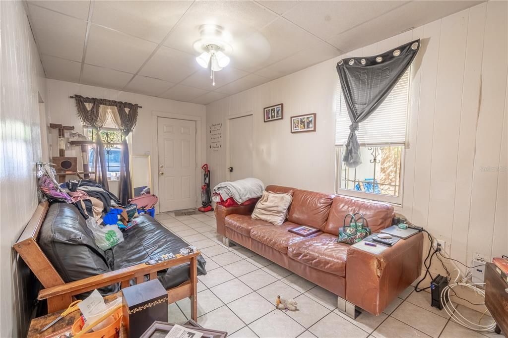 Unit A, Ground Level, Living room has ceramic tile floor, neutral tones and a ceiling fan with light kit.