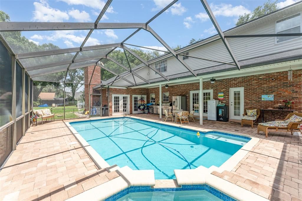 Relax by the screened-in large pool with a built-in Jacuzzi