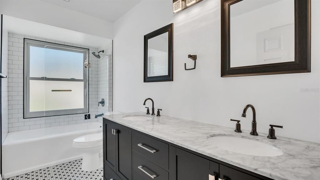 Remodeled upstairs bathroom with a tub and double sinks