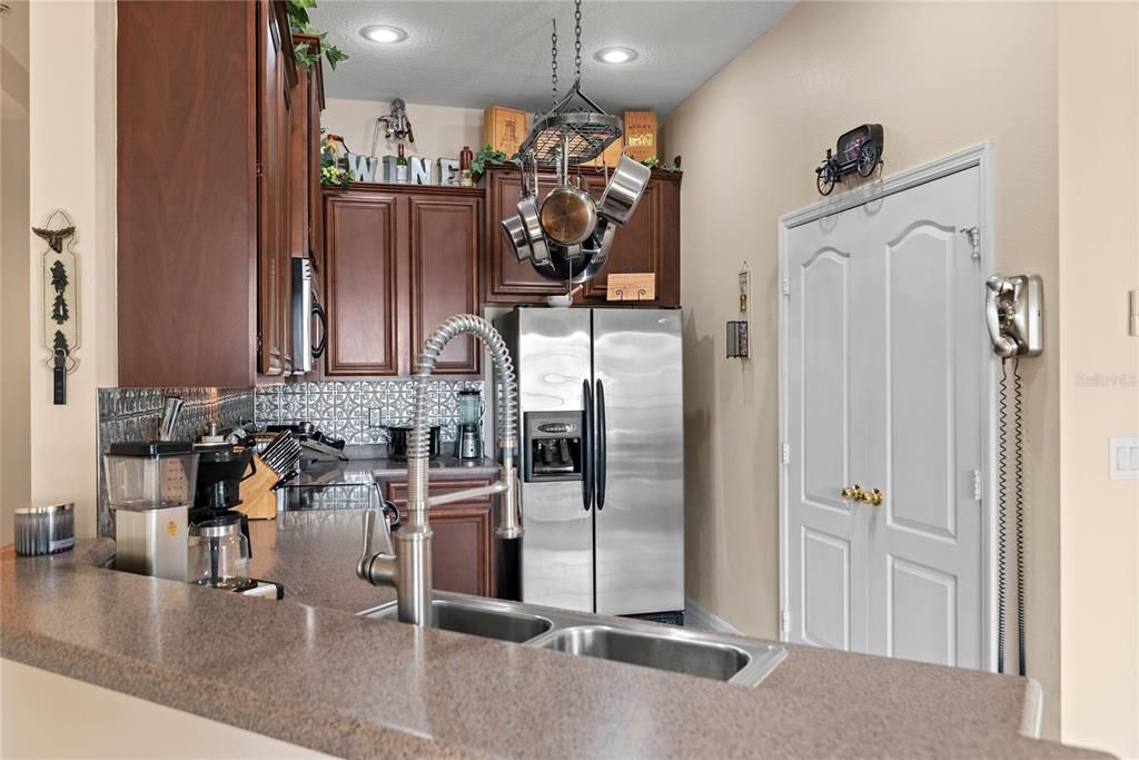 kitchen features Corian counters, stainless steel appliances, bar seating and 42 inch solid wood cabinets