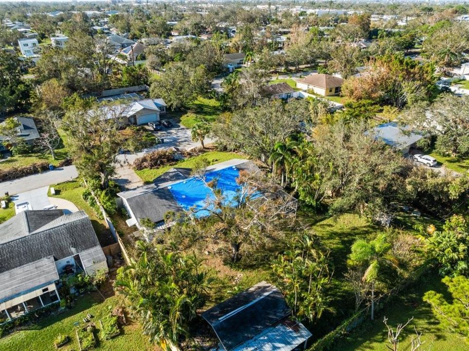 Aerial of the rear right side of the property showing the mature trees and vegetation.