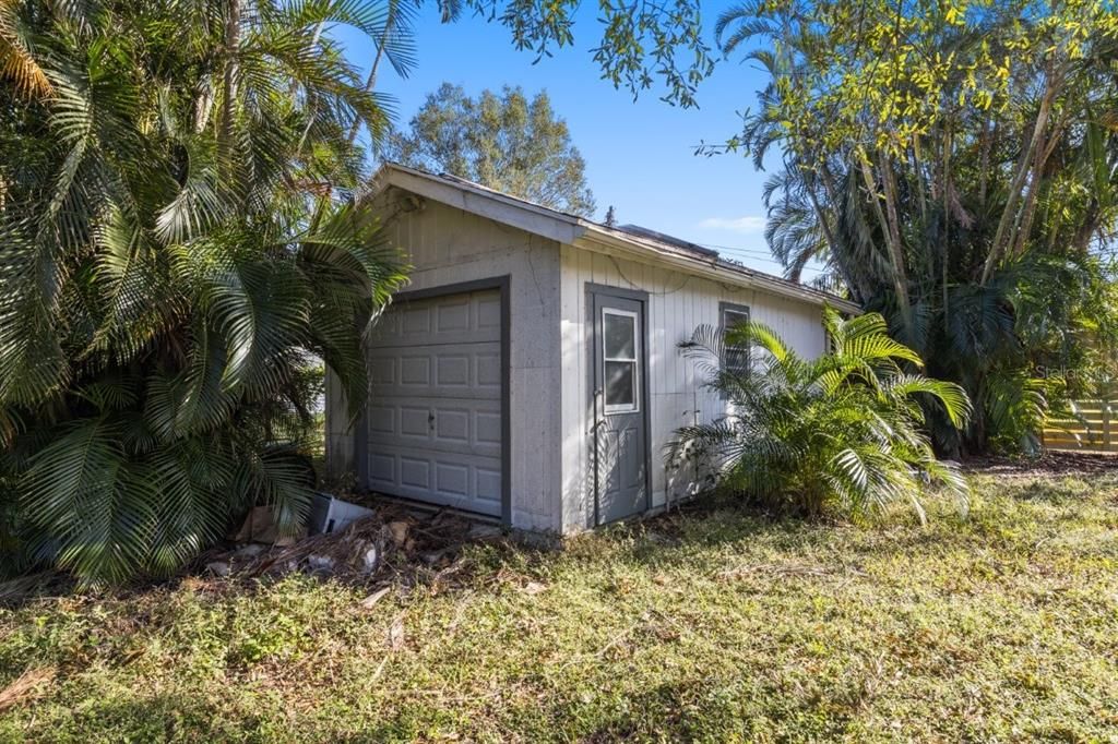 Workshop with electric and a garage door.