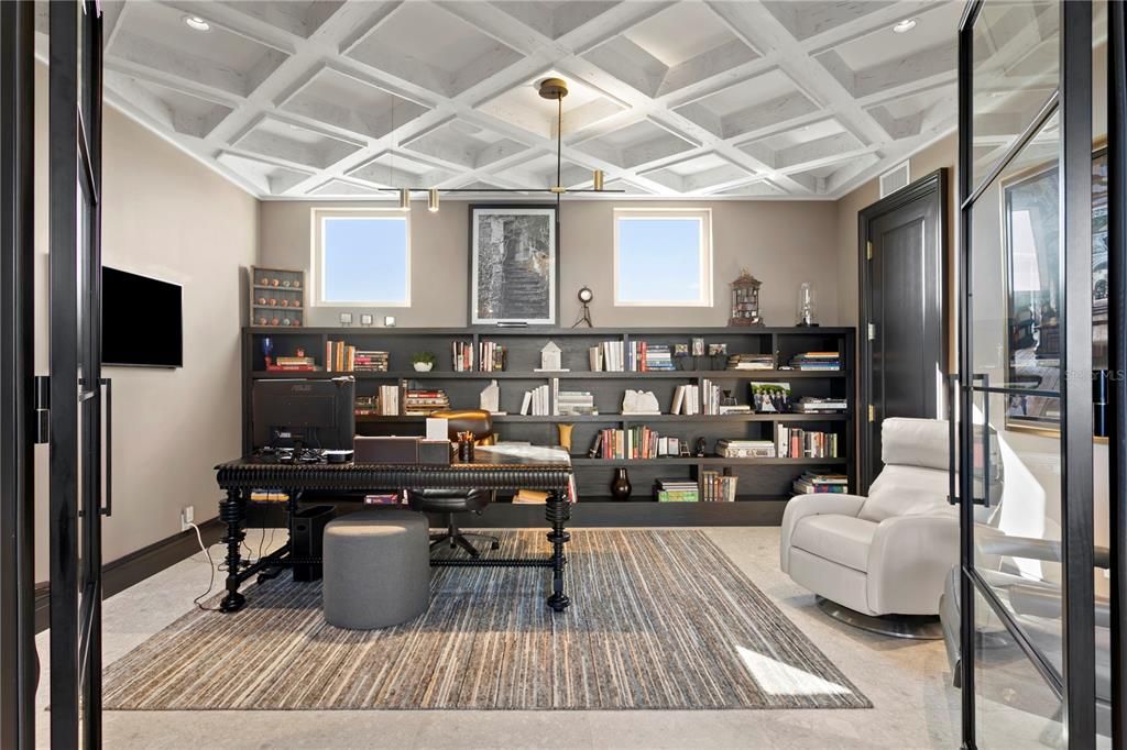 In-home office with glass wall and French doors.  The view is from the desk is all water