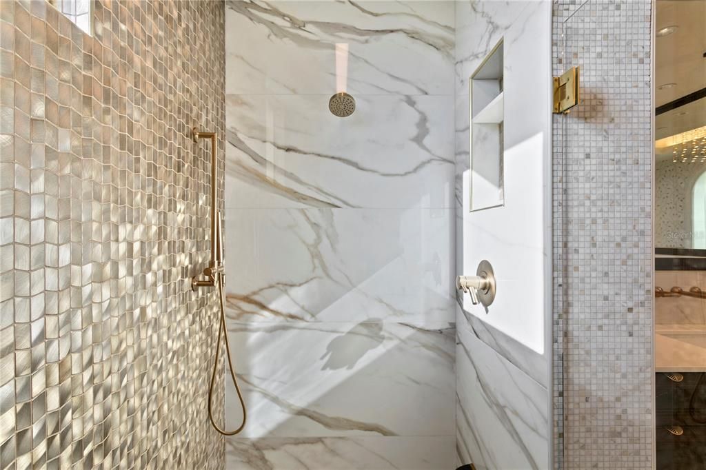 Primary suite shower with luxury marble and exquisite hardware