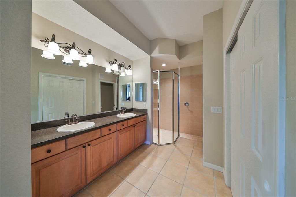 The ensuite bathroom boasts of granite counters, dual sinks, a modern glass shower, a secondary closet (his), a linen closet and a private water closet.