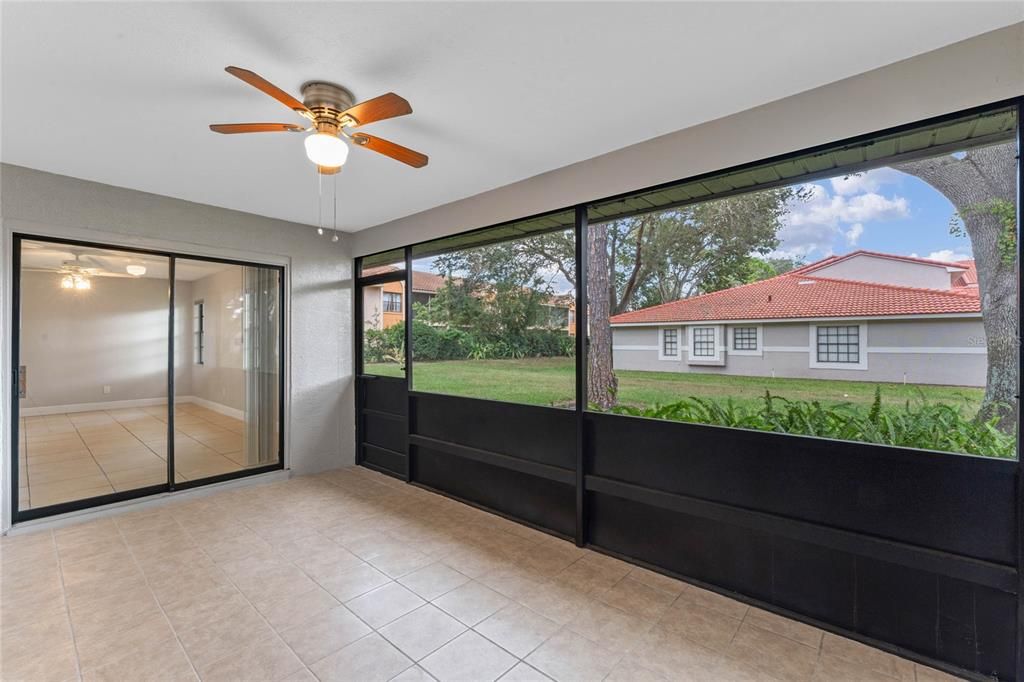 Screened patio with newer ceiling fan and tile flooring 2022