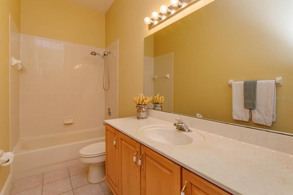 Hall bathroom with cultured marble vanity  and tile floor