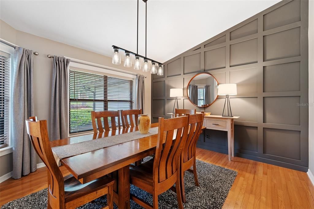 Dining room with new millworker wood accent wall, hardwood floors, new lighting and exquisite custom painting