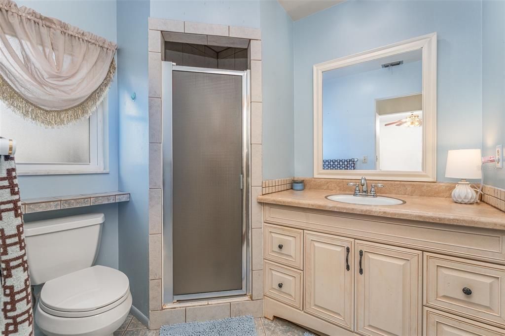 Primary bath with updated tile shower and vanity.