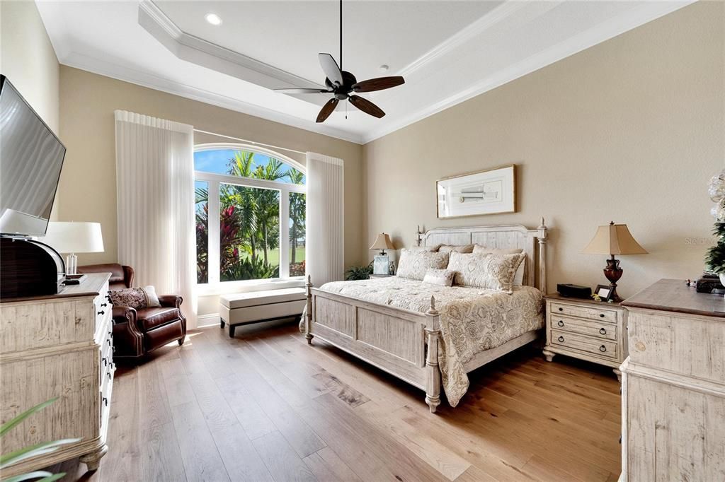 Primary Bedroom with tray ceiling and new hardwood flooring