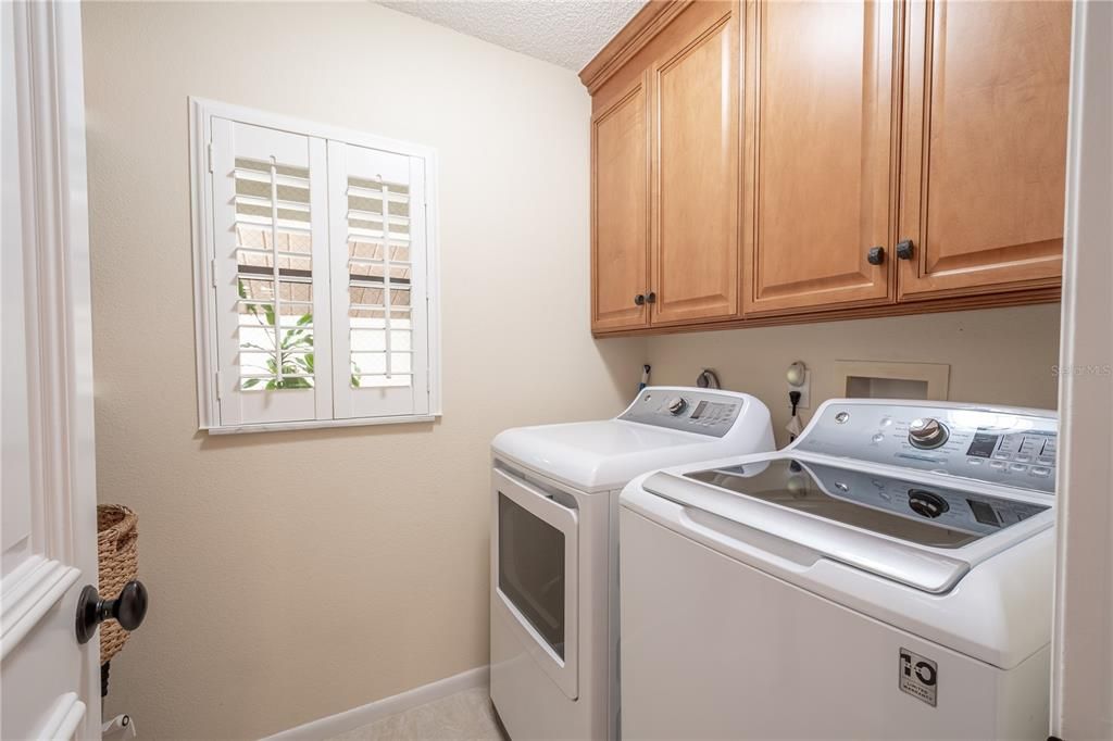 The laundry room, features hook ups for your washer and dryer and built in cabinets overhead for storage.