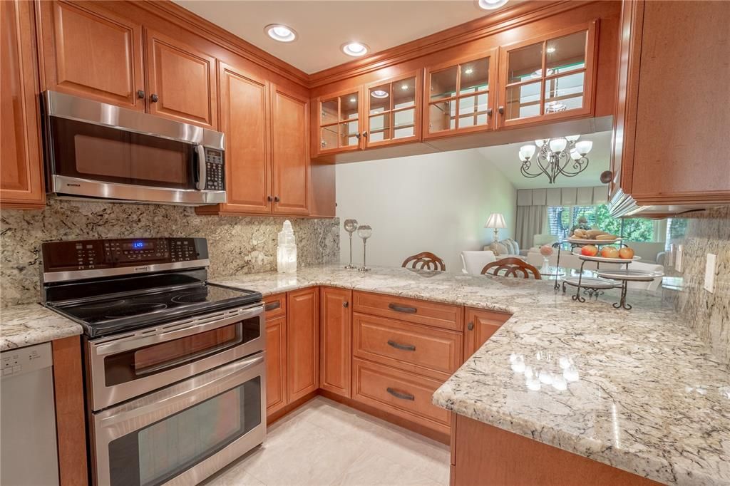 The kitchen features granite counters and backsplash, recessed lighting and ceramic tile flooring.