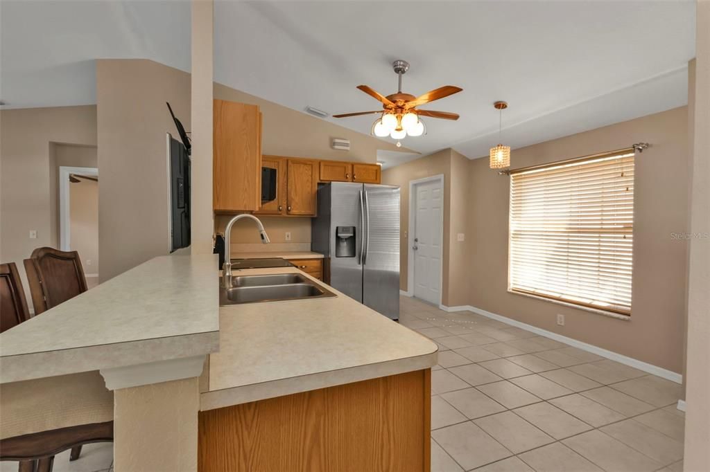 Kitchen features stainless steel appliances, wood cabinets, breakfast bar and breakfast nook.