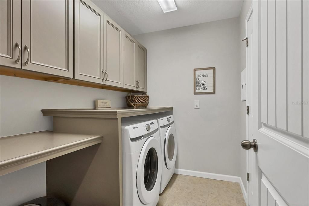 Laundry Room with Wood Cabinets, Counter Tops, and Storage Closet