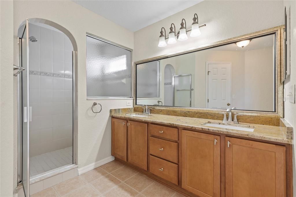 Primary bath with granite counter top, dual sinks, walk-in shower