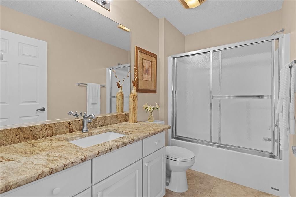 The guest bathroom includes GRANITE countertops and a shower/tub combo with a linen closet nearby for added convenience.