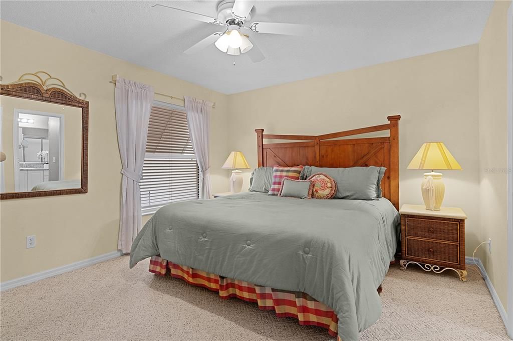 The primary suite comfortably fits a king-size bed and includes a walk-in closet with ample shelving.