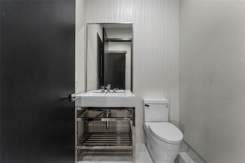 Main floor half bathroom: Conveniently located near the mudroom and laundry, this sleek half bath features modern finishes and is perfectly positioned for easy access from the garage or main living areas