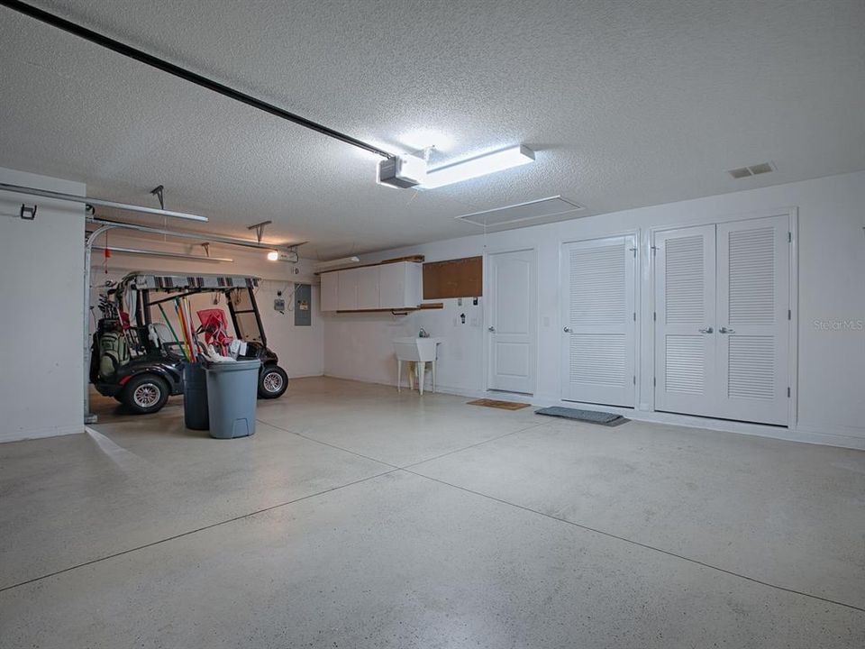 STORAGE SPACE, A TUB SINK AND CABINETS IN THE GARAGE