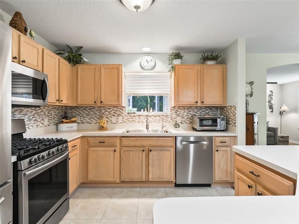 Open Concept Kitchen with SS Appliances and Tiled Backsplash