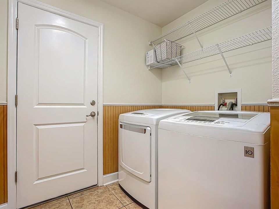 Laundry room with shelving and door to garage