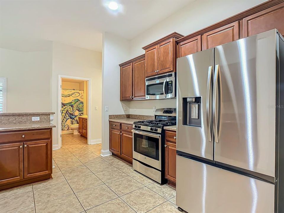 Right side of kitchen with gas stove, microwave & refrigerator