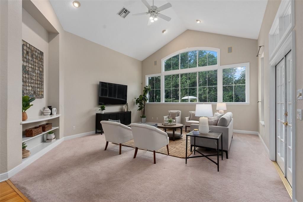 Oversized family room with vaulted ceilings and lots of windows.  French door lead to screened pool and patio area.