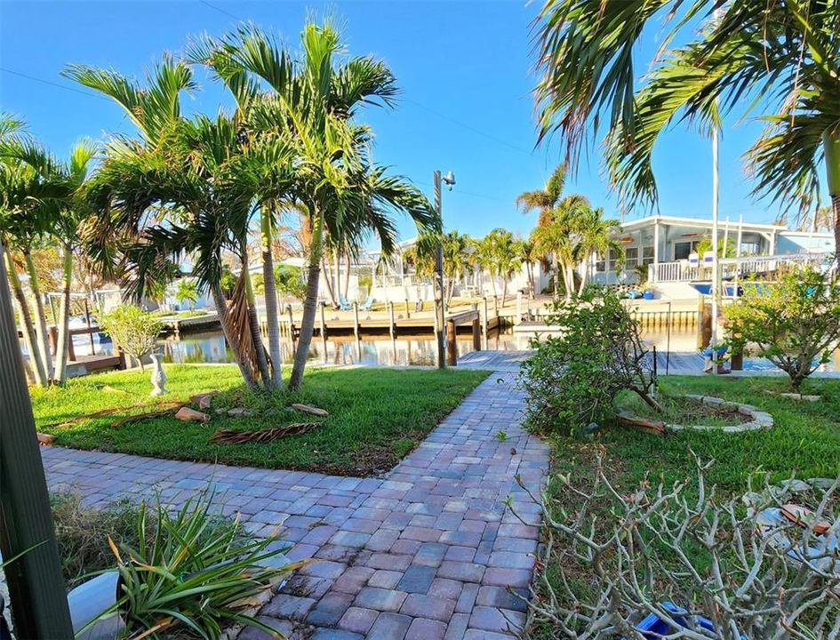 View looking west. Rear yard to canal and dock on right, ramp on left