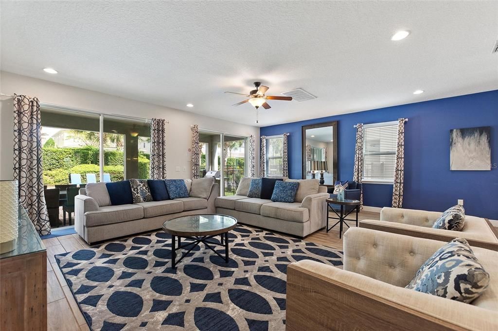 An inviting gathering space with natural lighting between the sliding glass doors and the windows.