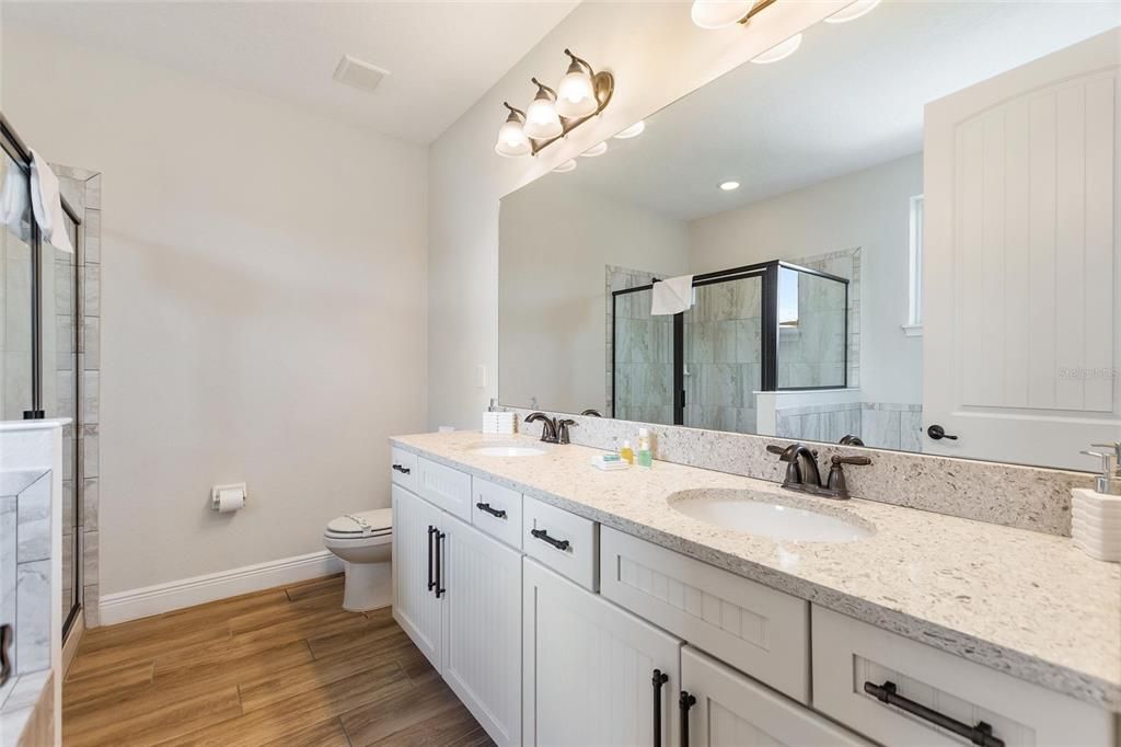 This guest bathroom has the double sink vanity, garden tub, and separate shower stall.