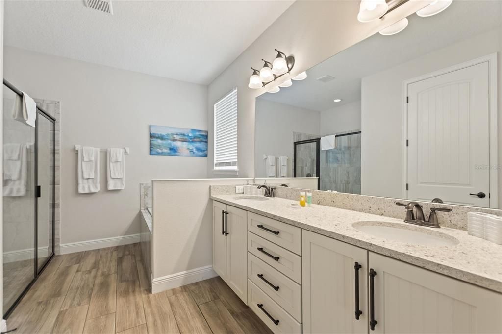 This bathroom provides a garden tub, separate shower stall, and double sinks.