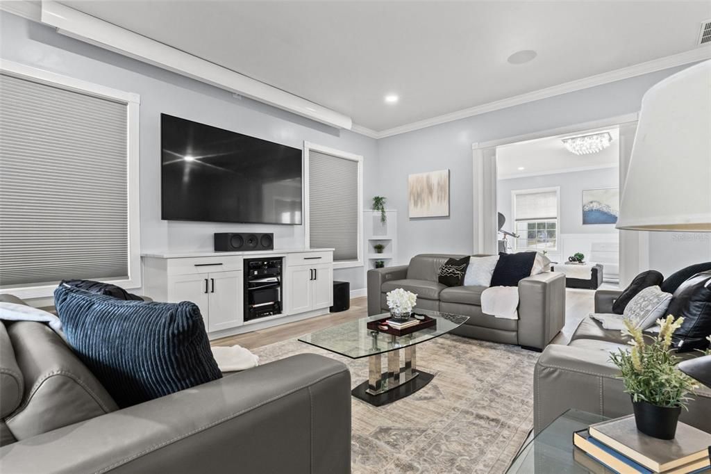 Living Room with built in speaker and sliding doors that lead to the pool and backyard oasis