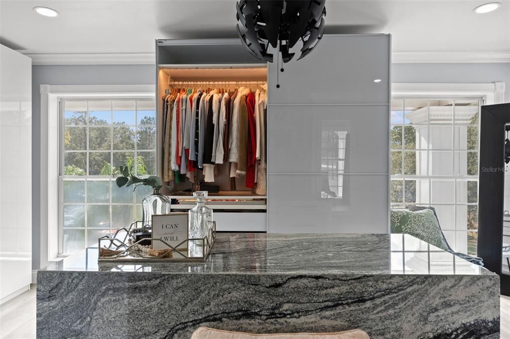 Grand Walk-In Closet with a Central Island, Custom Wardrobes, and a Secure Armory Room